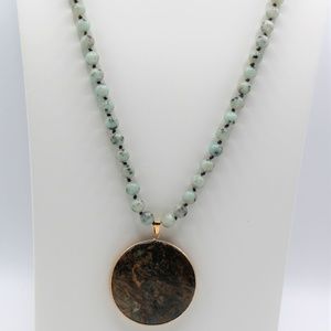 Long knotted green necklace with round pendant